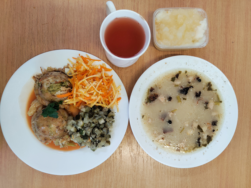 Na zdjęciu znajduje się: Barszcz biały z ziemniakami, Risotto z mięsem wieprzowym i warzywami, Sos pomidorowy, Cukinia pieczona z olejem, Surówka z selera i marchwi z olejem, Kompot owocowy, Kasza manna z jabłkiem prażonym